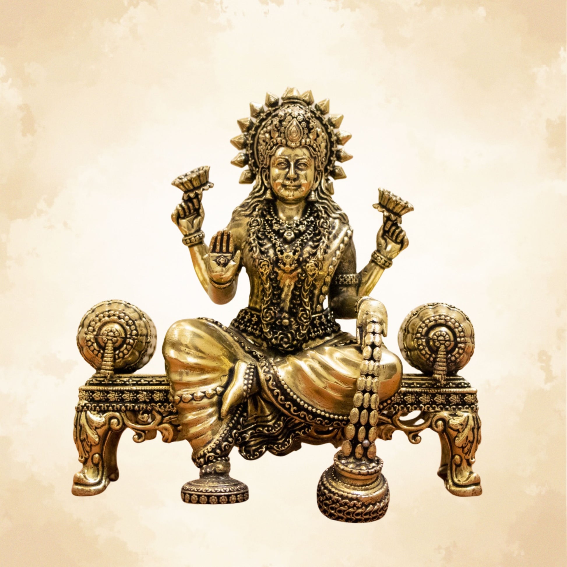 Brass Lakshmi idol seated on an ornate singhasan with detailed carvings and antique finish.